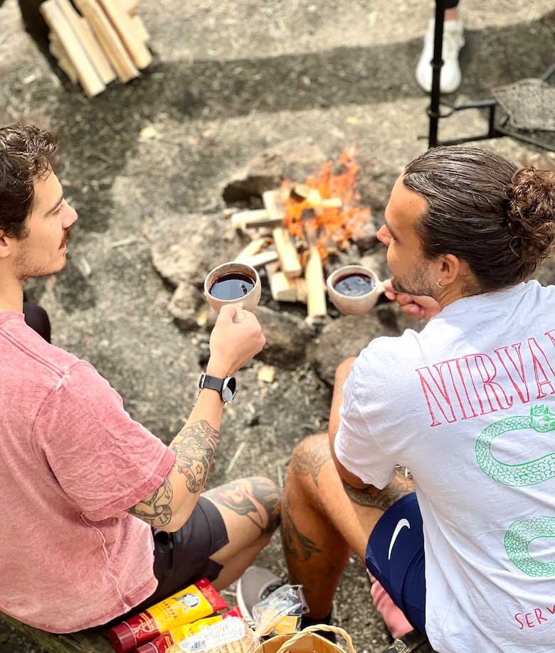 two men sitting by the campfire in nuuksio national park