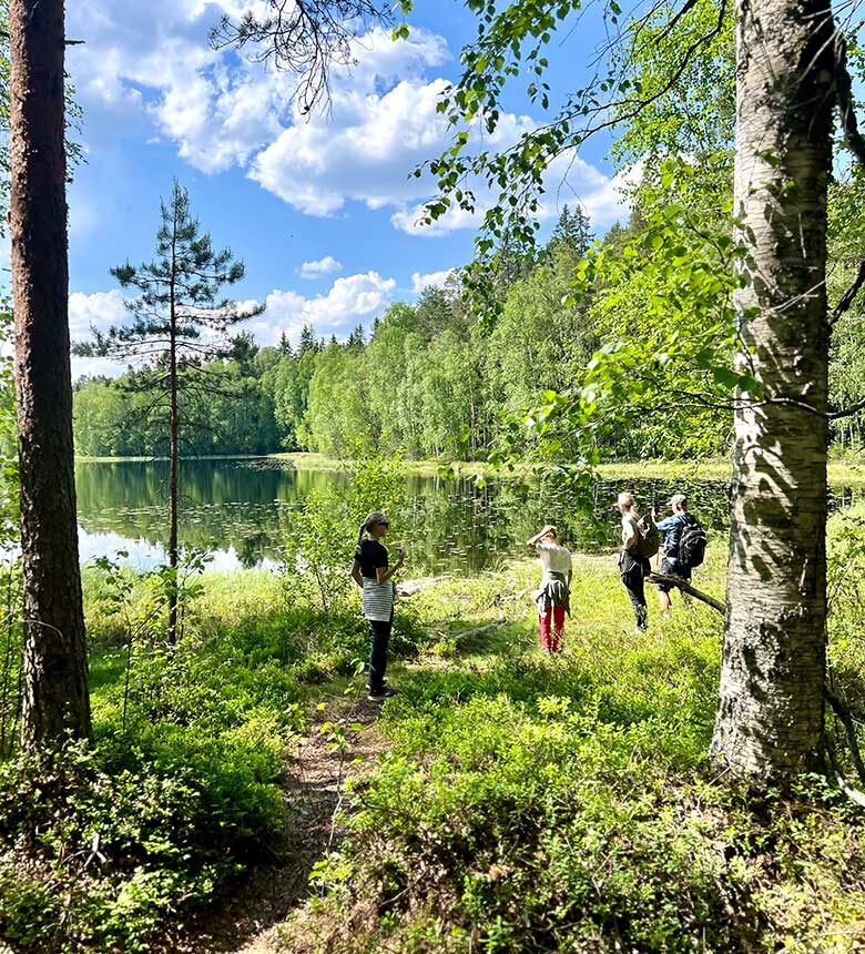 people by a lake in finnish national park